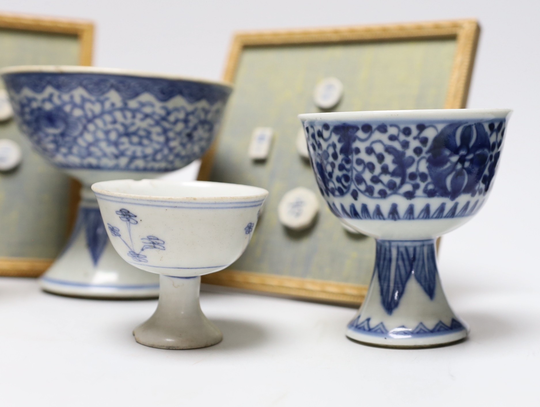 Five 19th century Chinese blue and white stem cups and two framed sets of Thai gaming counters, tallest cup 11cm